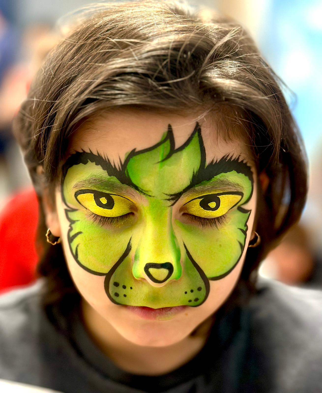 A young person with a green face painting